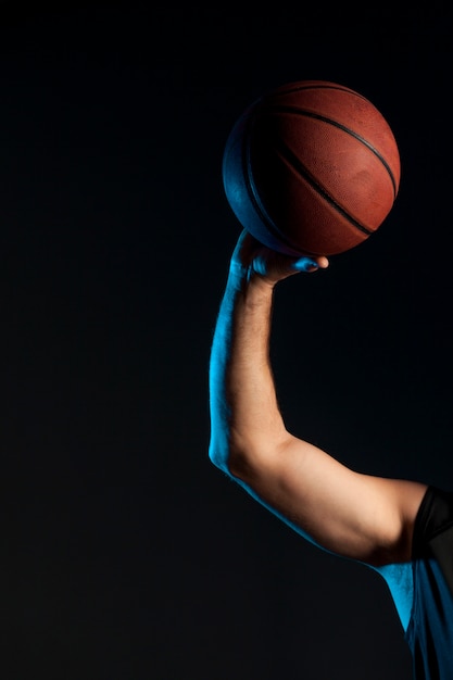 Free photo front view of basketball player arm holding up ball