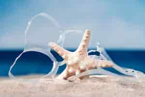 Free photo front view of beach with starfish and plastic