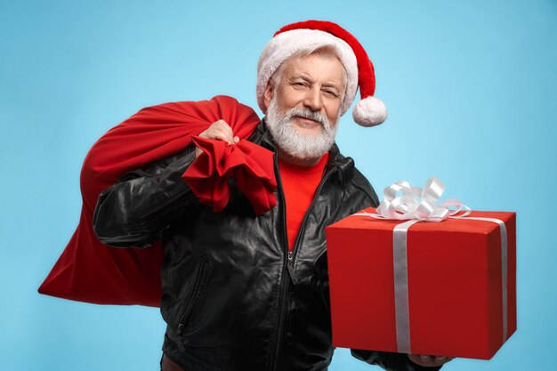 Front view of bearded man in santa hat with gift boxes