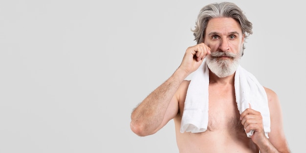 Front view of bearded senior man with towel