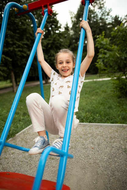 Front view of beautiful happy girl in swing