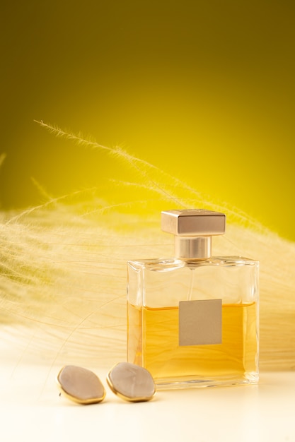 Free photo front view of beautiful light perfume inside flask on the yellow surface