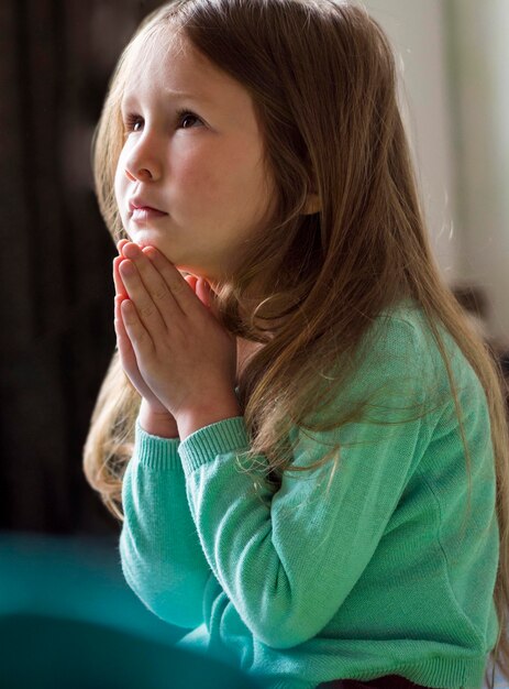 Front view of beautiful little girl praying