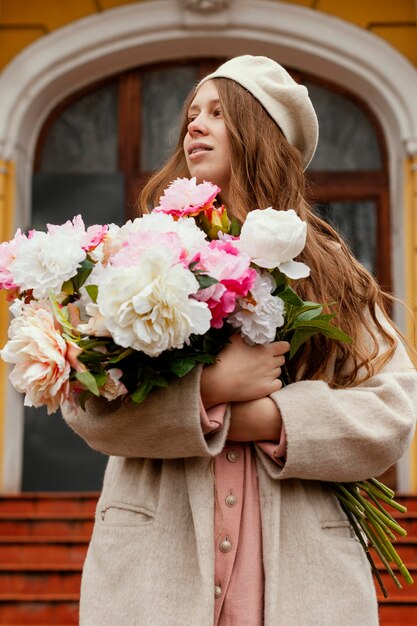 Front view of beautiful woman holding bouquet of flowers