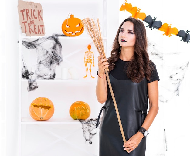 Free Photo front view beautiful woman with halloween broom