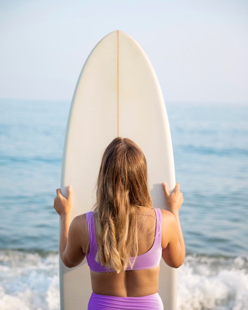 Free photo front view of beautiful woman with a surfboard