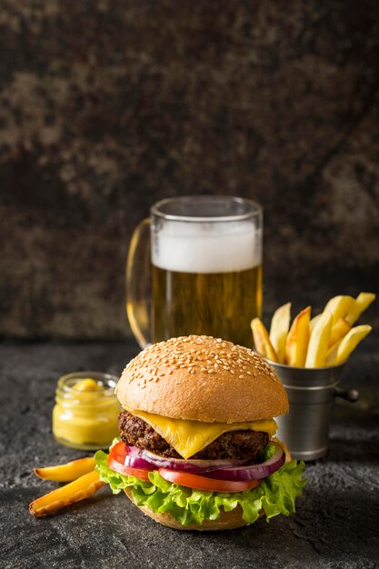 Front view beef burger, fries and sauce with beer and copy-space