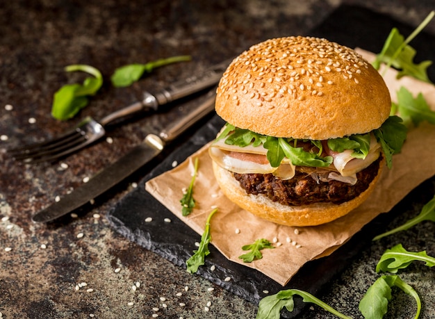 Free photo front view beef burgers with bacon and cutlery