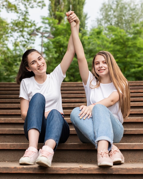 Free Photo front view best friends posing on stairs