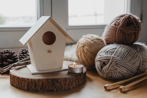 Free Photo front view bird house and yarn with candle