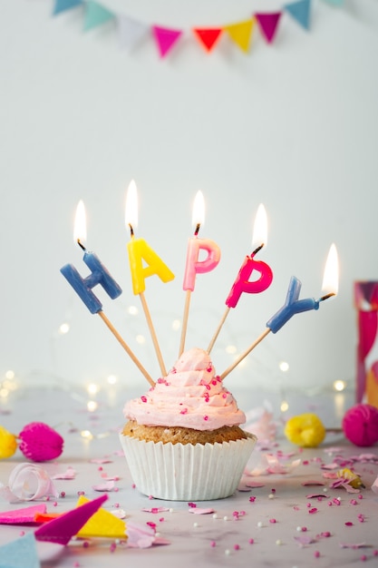 Free photo front view of birthday cupcake with lit candles