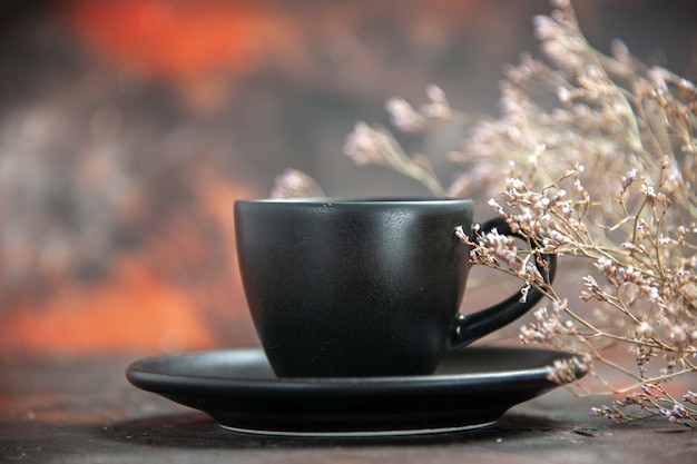 Front view black cup and saucer on dark red table with free place