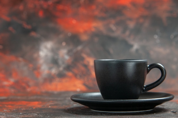 Front view black cup and saucer on dark red table