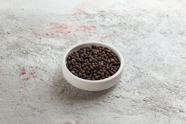 Front view black pepper little inside white pot on white surface