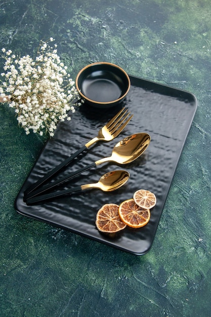 Free Photo front view black plate with golden cutlery on dark background