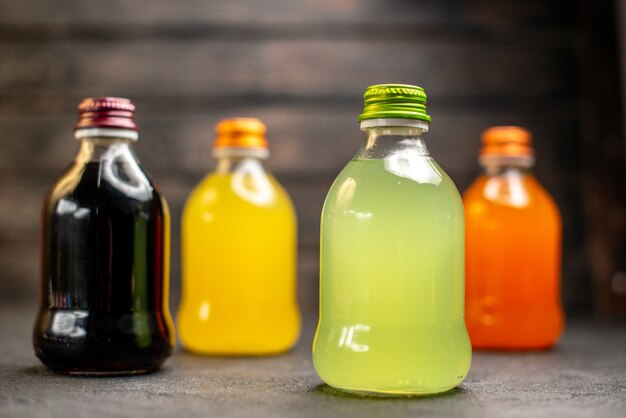 Free photo front view black yellow green and orange juice in bottles