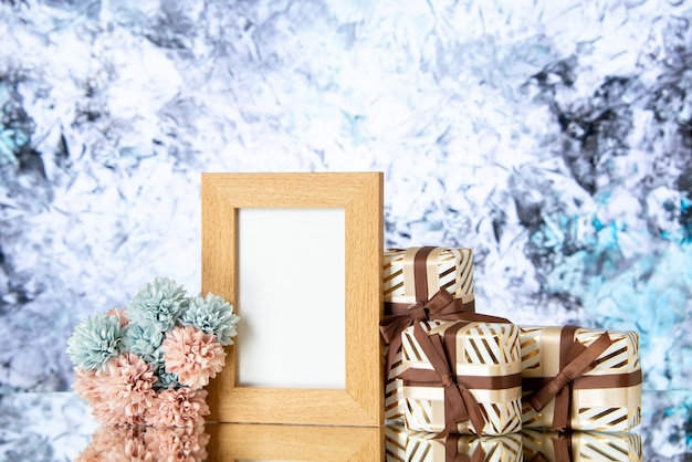 Front view blank picture frame holiday presents on light abstract background