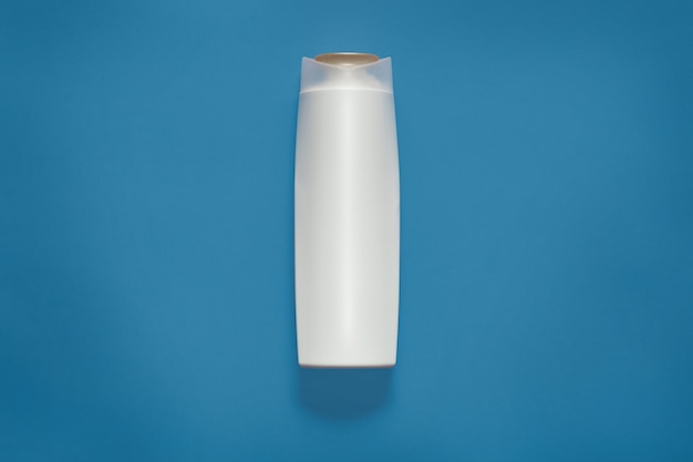 Free photo front view of blank white plastic cosmetics bottle isolated on blue studio, empty cosmetic container, mock up and copy space for advertisment or promotional text. beuity concept.