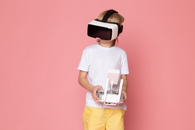 Free photo a front view blonde kid playing vr in white t-shirt on the pink space