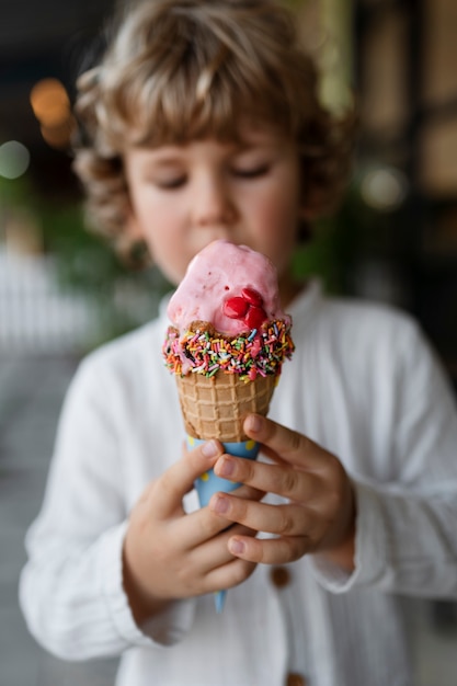 Front view blurry kid holding ice cream cone