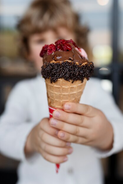 Front view blurry kid holding ice cream