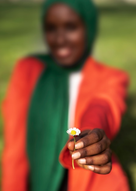 Free Photo front view blurry woman holding flower