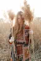 Free photo front view of bohemian woman posing in nature field