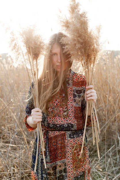 Free Photo front view of bohemian woman posing in nature field