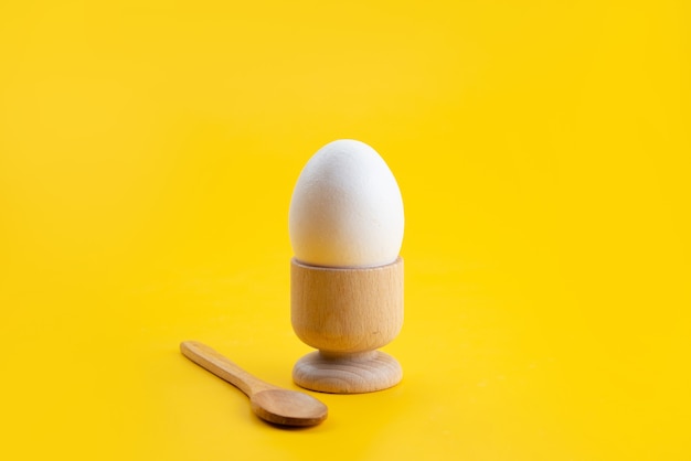 Free photo a front view boiled egg inside little stand on yellow, food meal color