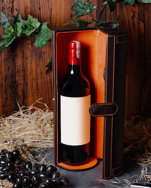 Free photo a front view bottle of wine red wine with burgundy cap inside box alcohol winery