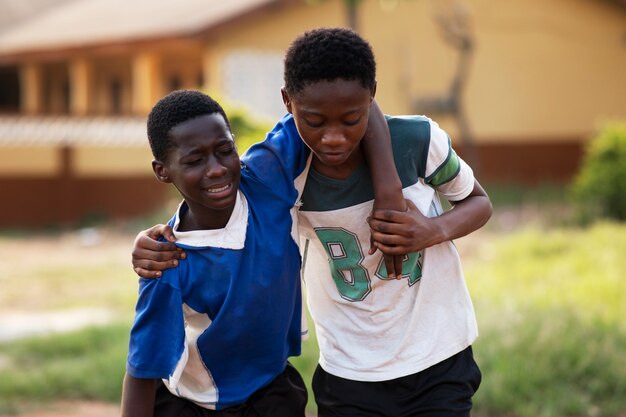 Front view boy carrying crying friend