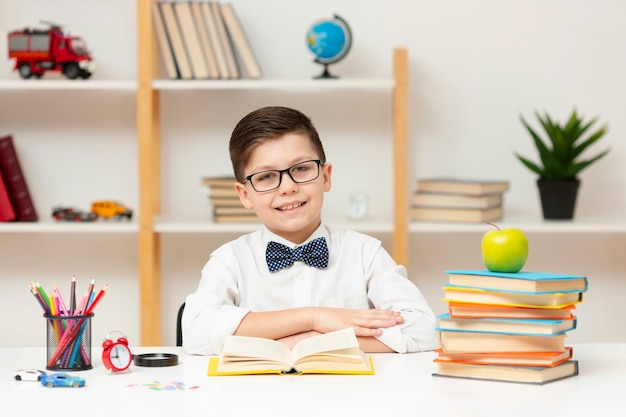 Front view boy at desk reading