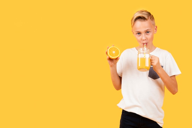 Front view boy drinking orange juice