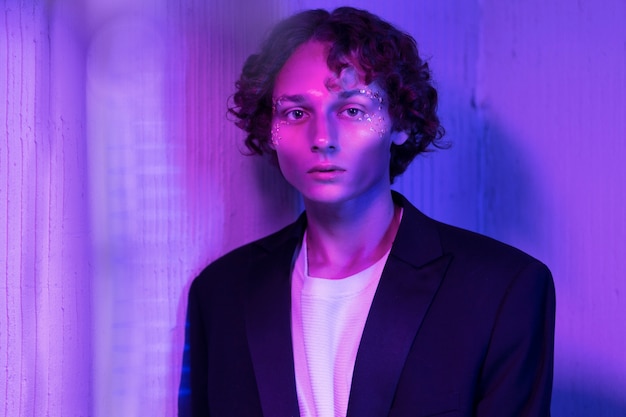 Free photo front view boy posing with neon light