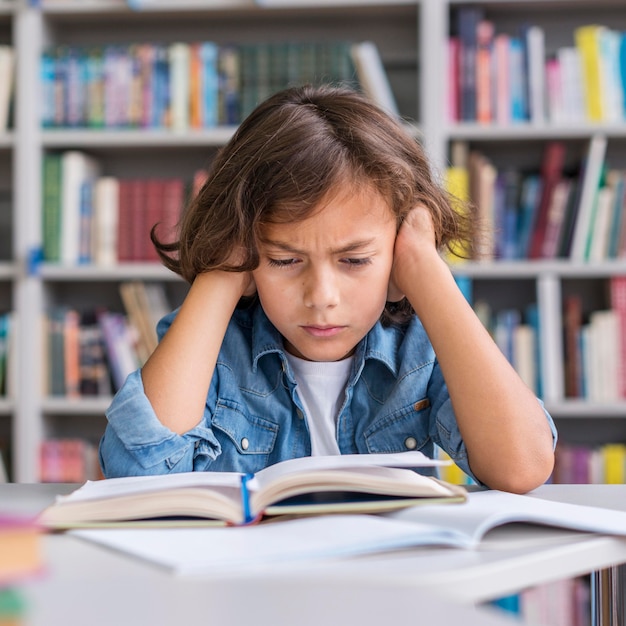 Front view boy thinking hard about how to solve his homework