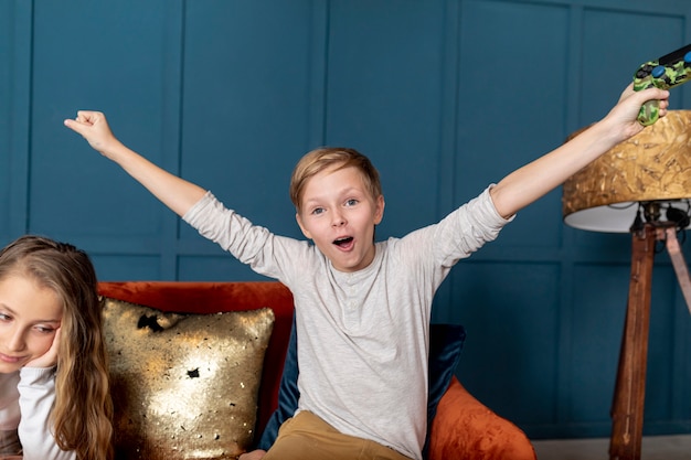 Front view boy winning at playing video games with his sister