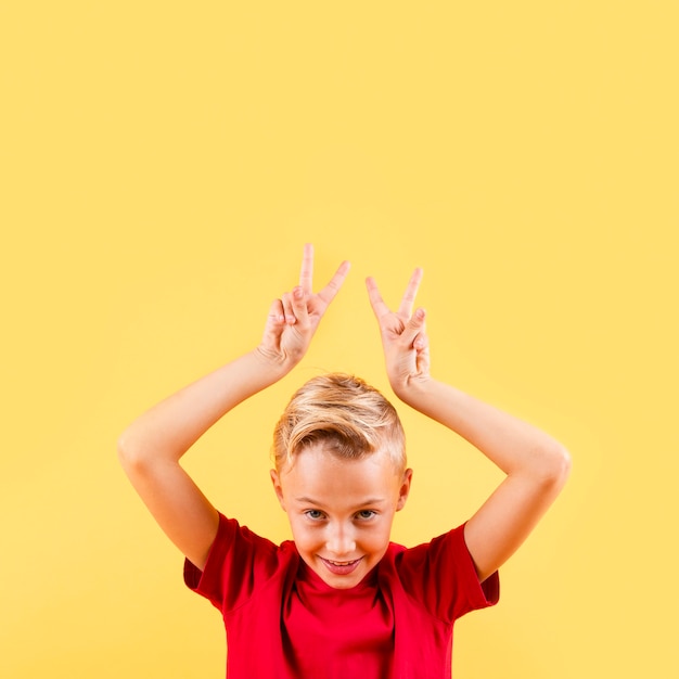 Free Photo front view boy with peace sign above head