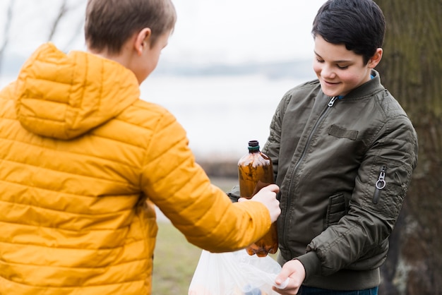 Free photo front view of boys with plastic bag