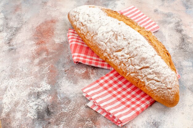 Front view a bread on red kitchen towel on nude