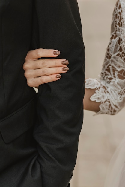 Free photo front view of bride holding groom's arm