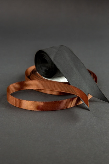 front view brown bow with black bow on dark surface darkness pin sewing measure photo colors