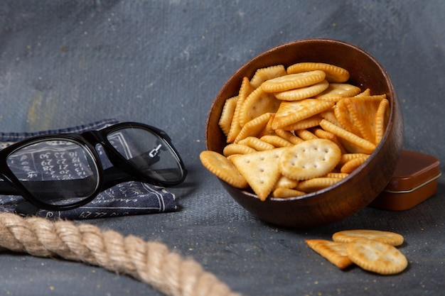 Free photo front view of brown plate with salted crackers and sunglasses