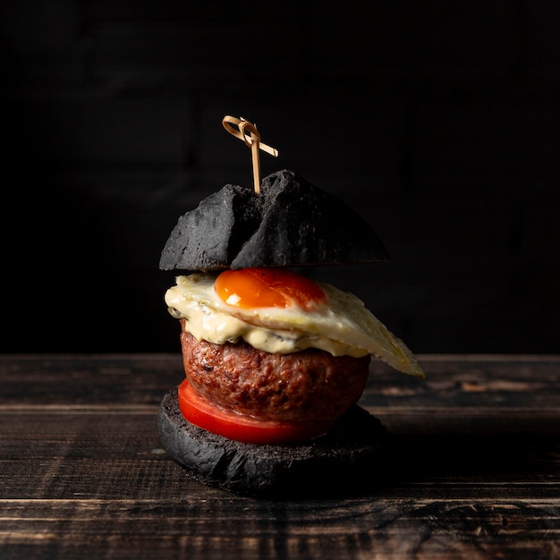 Free photo front view burger with egg on table