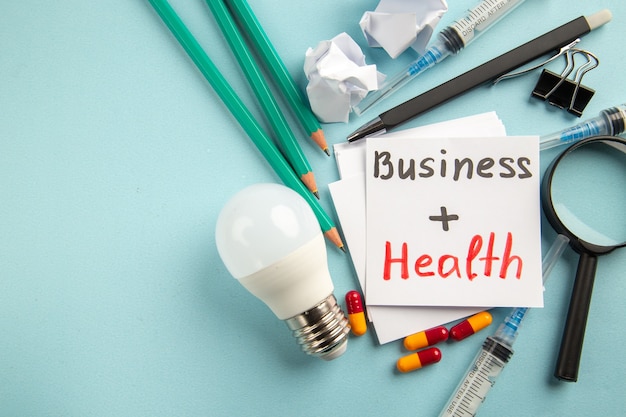 Free Photo front view business health with pills pencils and injections on blue background