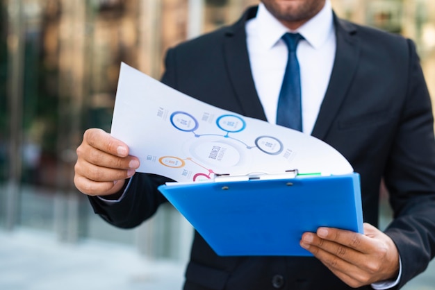 Free photo front view business man looking on charts