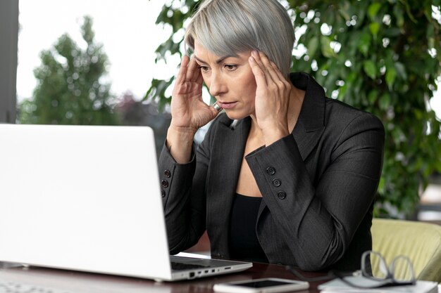 Front view business woman looking at laptop