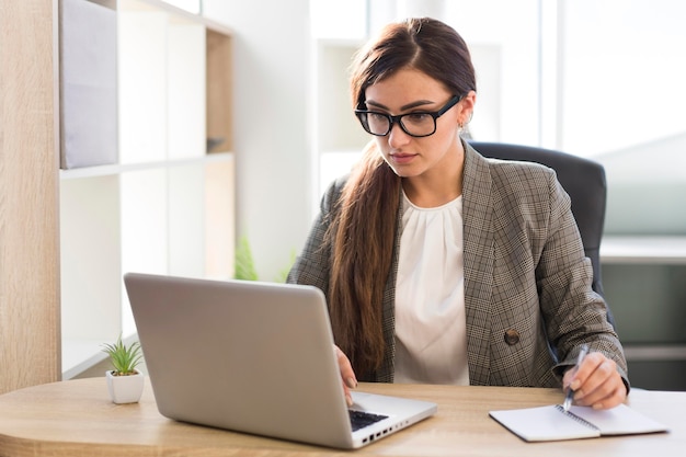 Front view of businesswoman working on laptop in the office