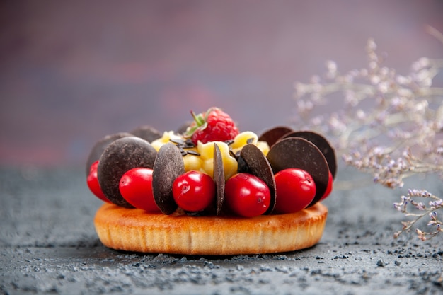 Free Photo front view cake with cornel fruit raspberry and chocolate on dark background