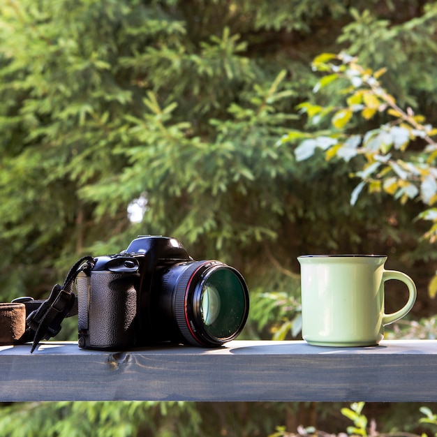 Free photo front view camera anc cup of coffee in nature