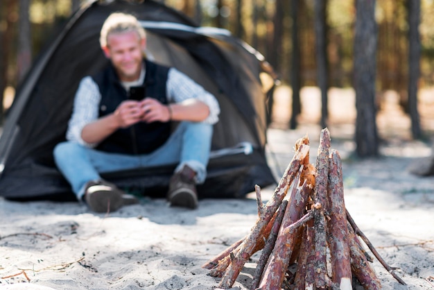 Front view campfire wood and blurred man